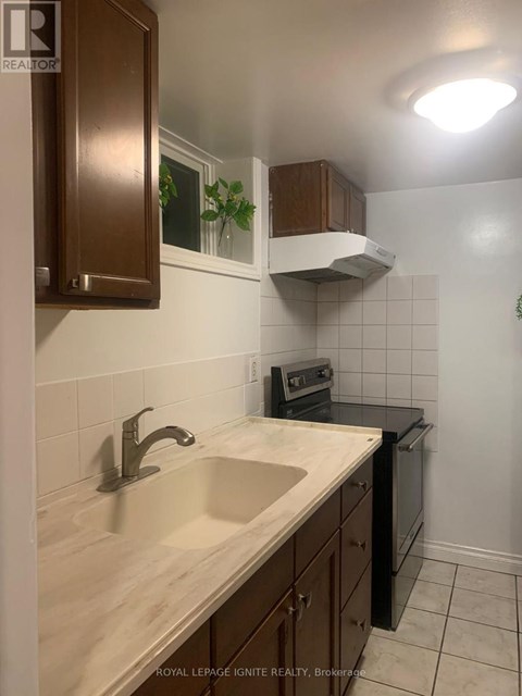 A kitchen with a sink and a stove top oven.