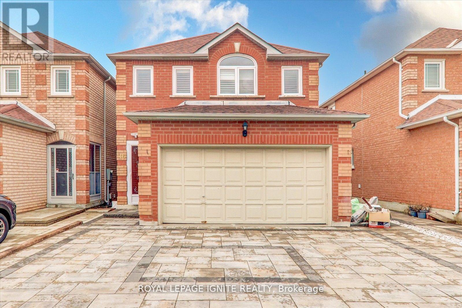 A large red brick house with a white garage door in front.