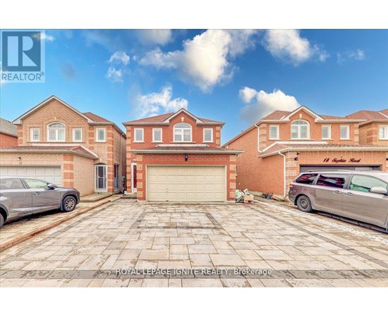 A large brick house with a garage and two cars parked in front.