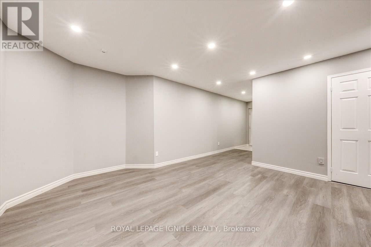 A spacious room with a white door and light grey walls.