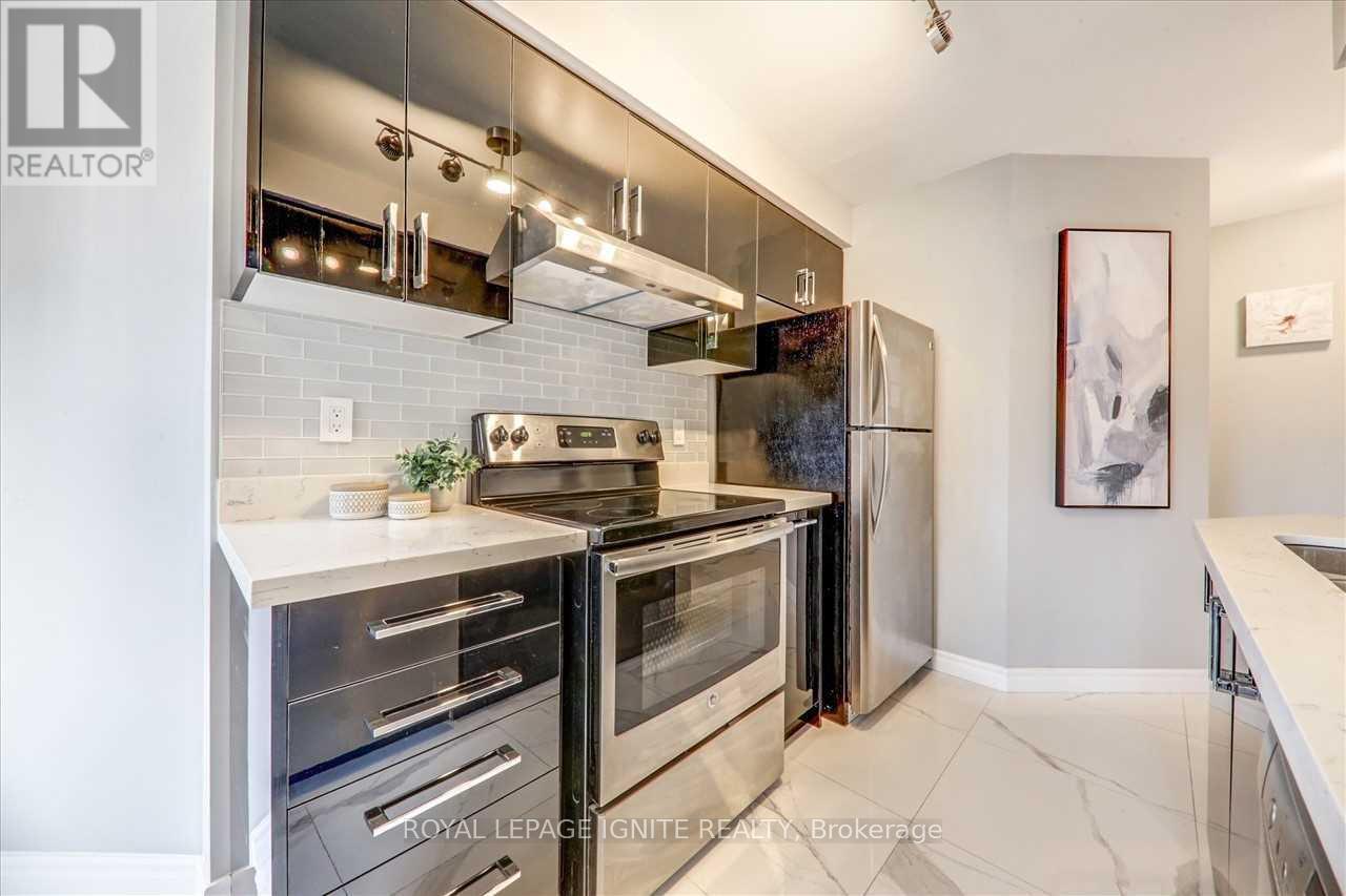 A modern kitchen with stainless steel appliances and a marble countertop.