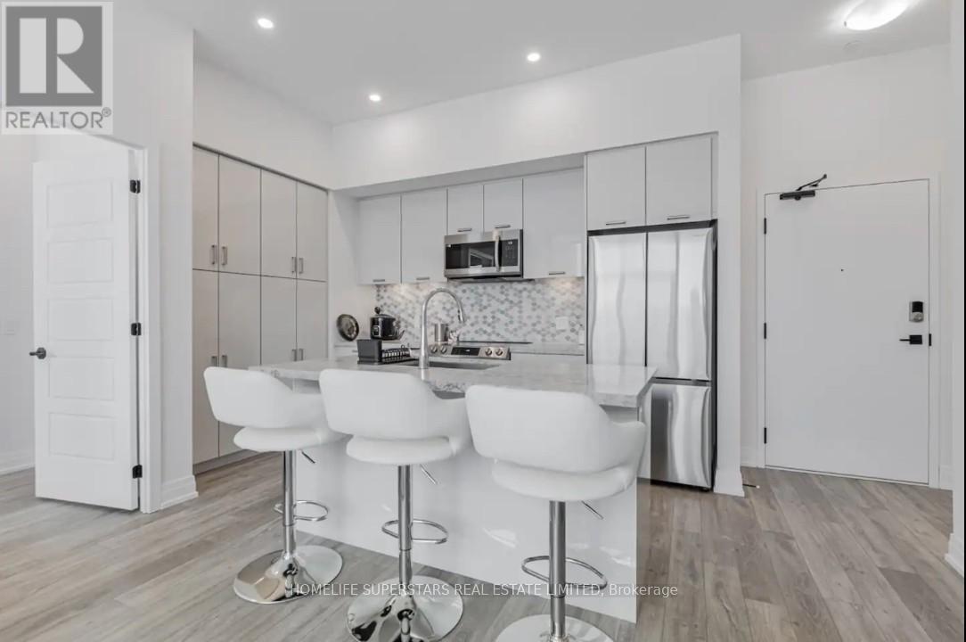 A modern kitchen with white chairs and a bar stool.