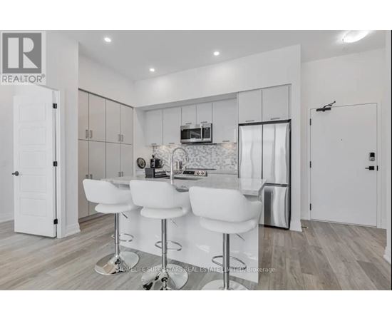 A modern kitchen with white chairs and a bar stool.