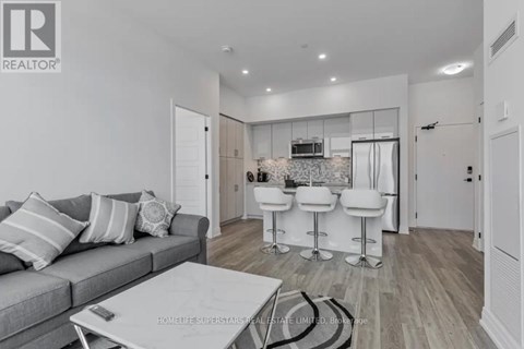 A living room with a grey couch and a white coffee table.