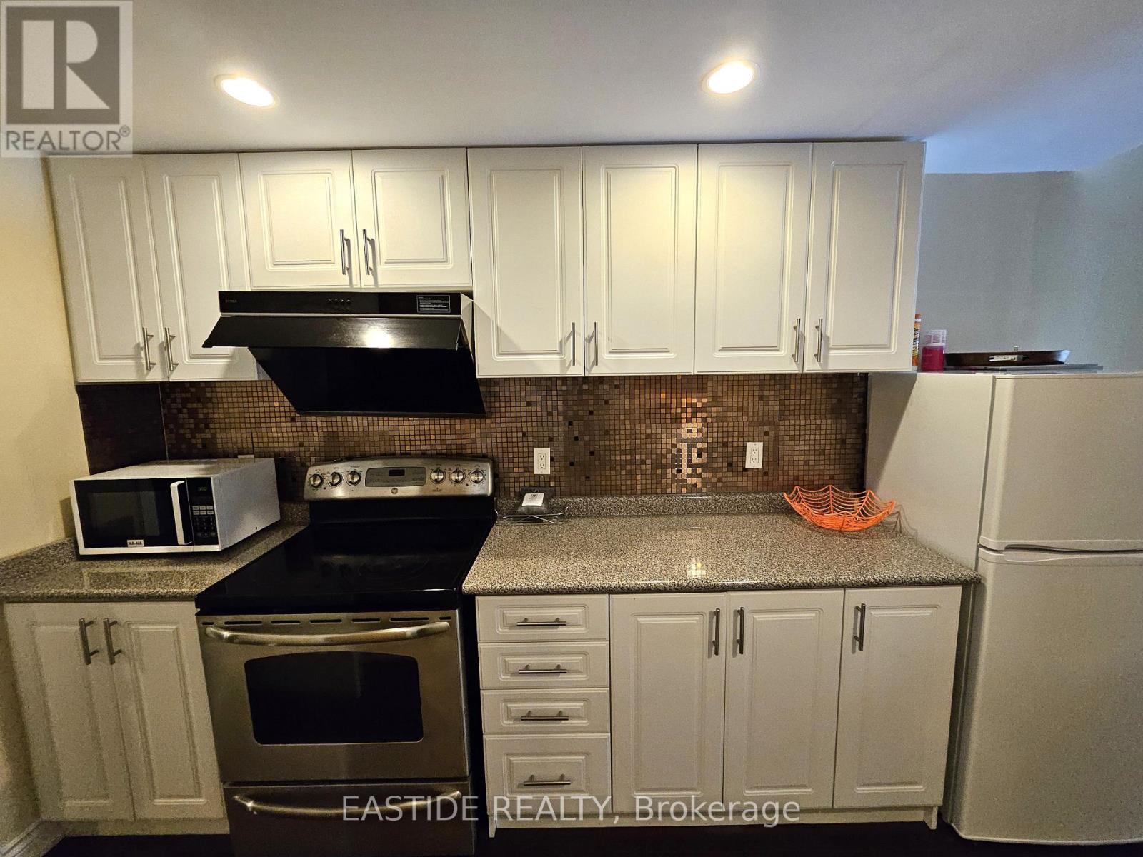 A kitchen with white cabinets and a black stove top.