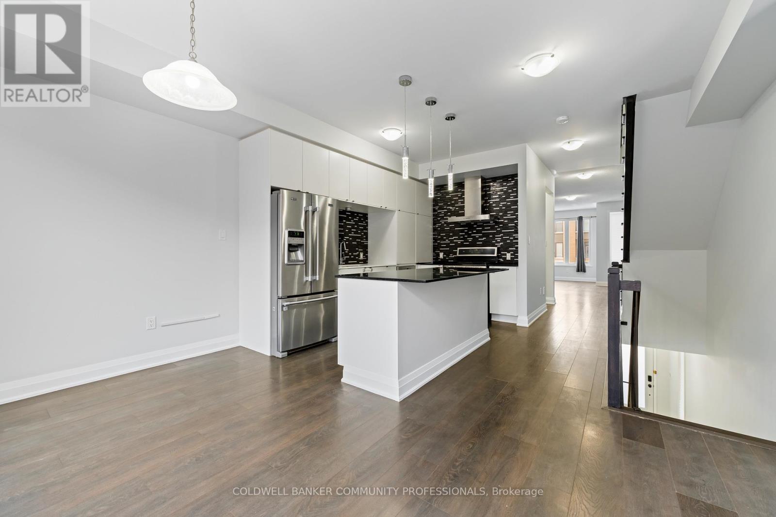 A spacious kitchen with white cabinets and a black countertop.