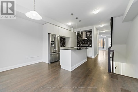 A spacious kitchen with white cabinets and a black countertop.