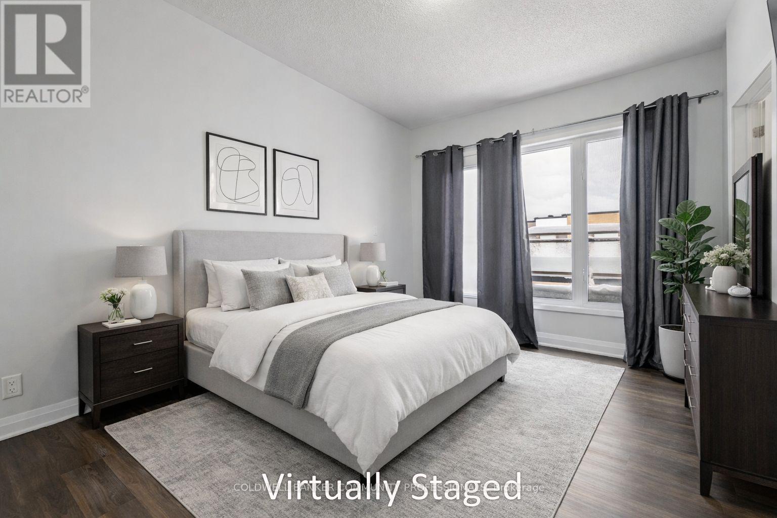 A bedroom with a large bed, two nightstands, and a window with curtains.