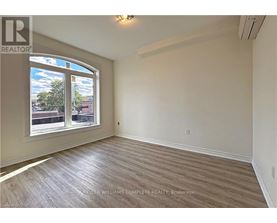 A room with a large window and wooden flooring.