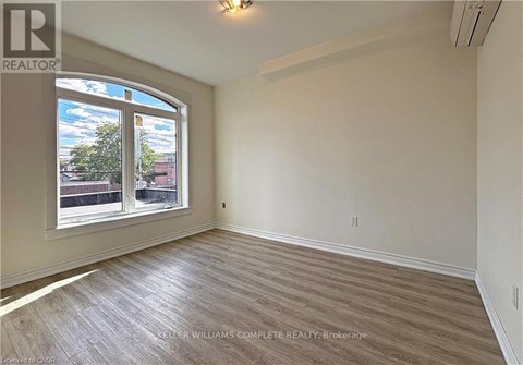 A room with a large window and wooden flooring.