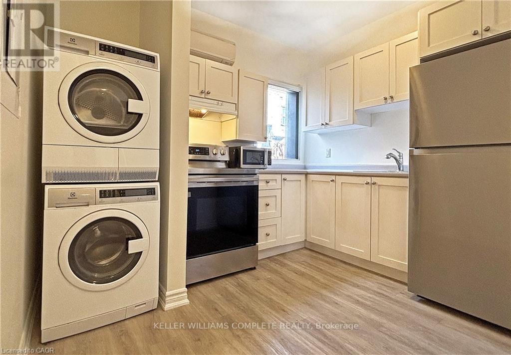 A kitchen with a washer and dryer stacked on top of each other.