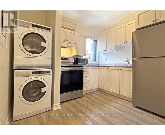 A kitchen with a washer and dryer stacked on top of each other.