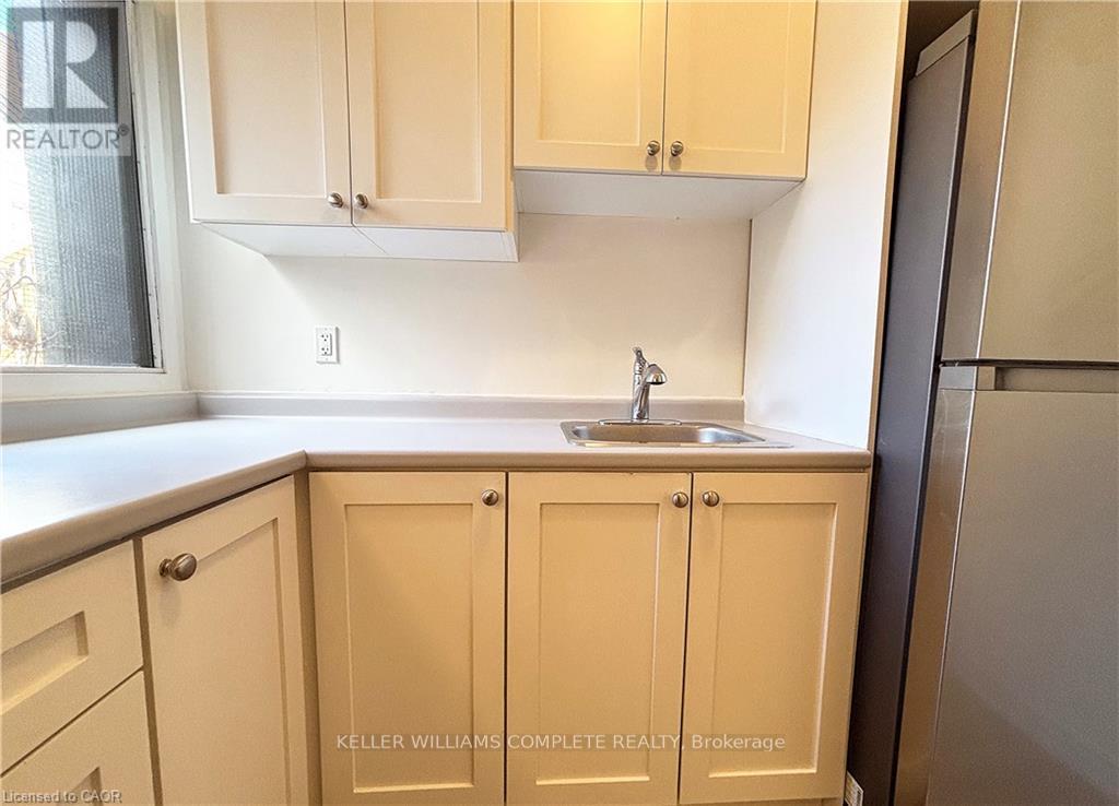 A kitchen with beige cabinets and a sink.