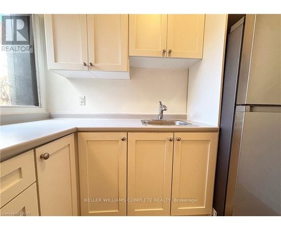 A kitchen with beige cabinets and a sink.