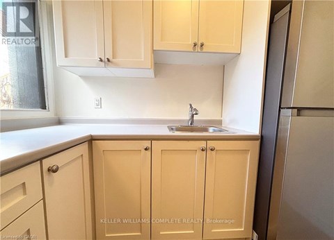 A kitchen with beige cabinets and a sink.
