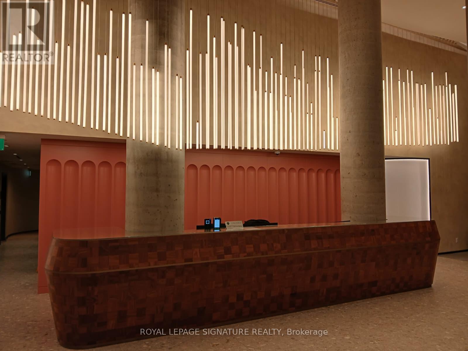 A reception area with a red wall and a brown reception desk.