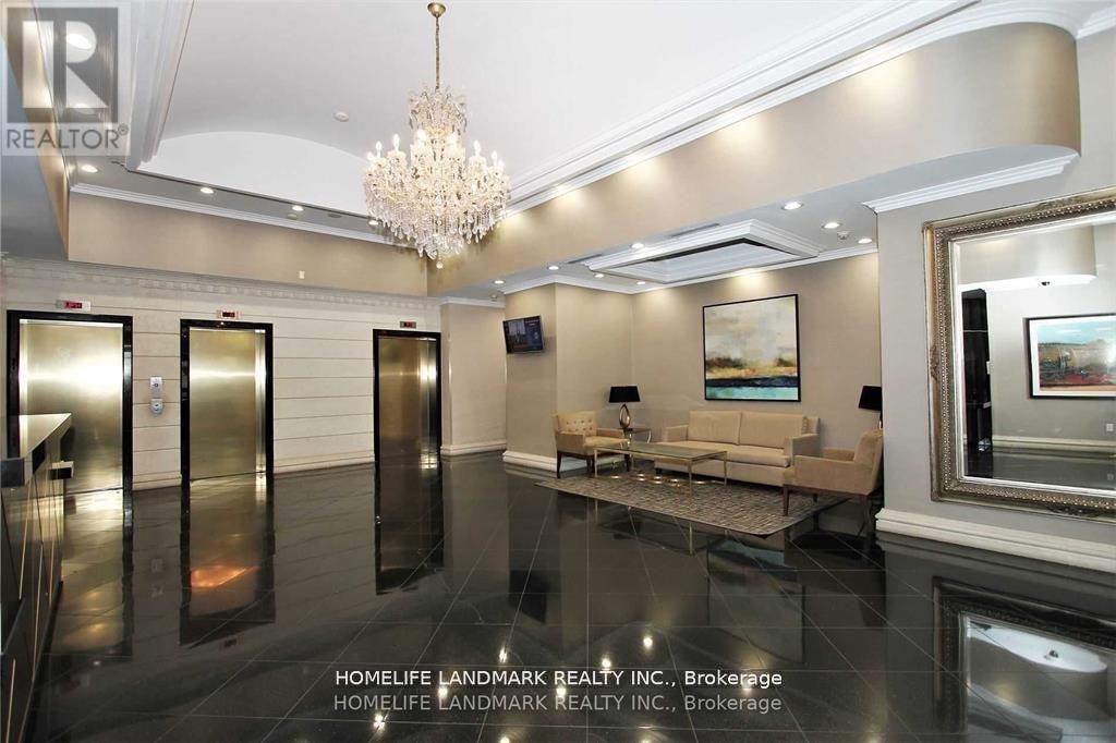 A spacious, well-lit room with a chandelier, a couch, and a television.
