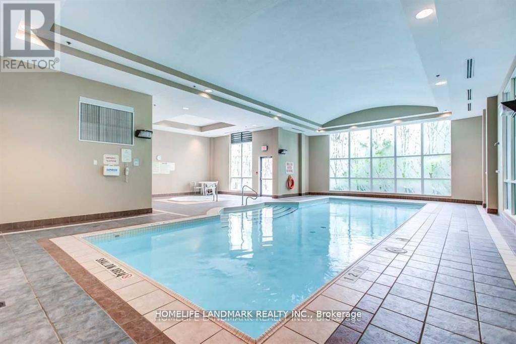 A large indoor swimming pool with a tiled floor and a glass wall.