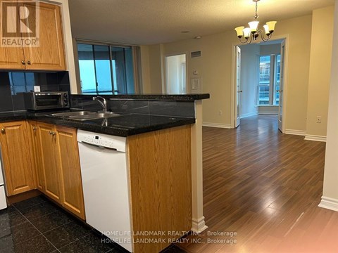 A kitchen with wooden cabinets and black countertops.