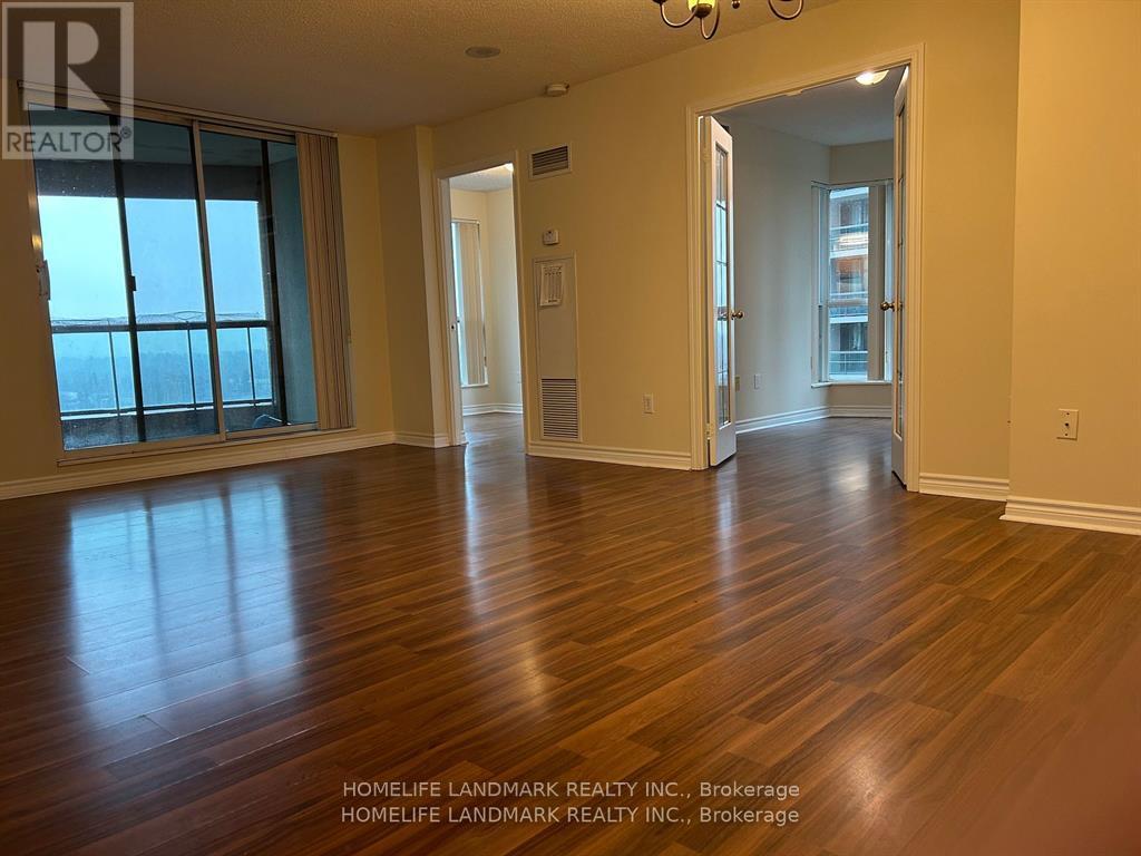 A room with wooden floors and a large window.