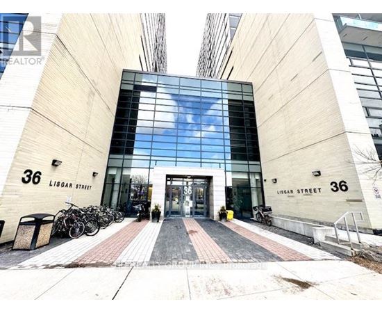The image shows the entrance to a building with the number 36 on the walls and a glass door.