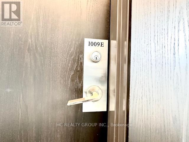A door handle with a keypad and a number 1009E on it.