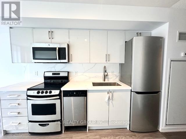 A kitchen with white cabinets and a stainless steel refrigerator.
