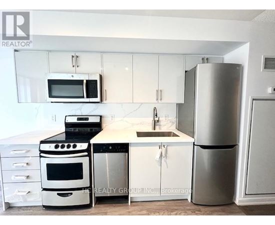 A kitchen with white cabinets and a stainless steel refrigerator.
