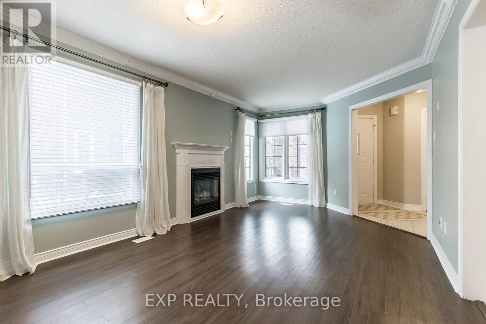 A spacious room with a fireplace and large windows.