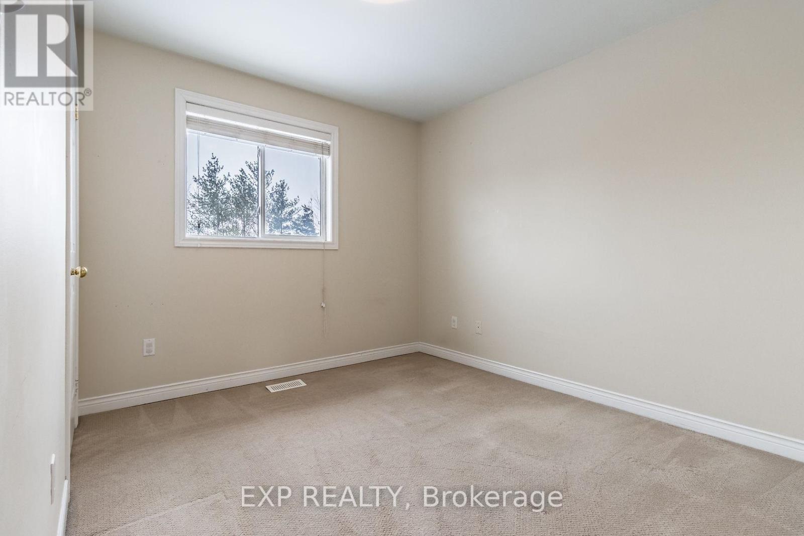 A room with a window showing trees outside.