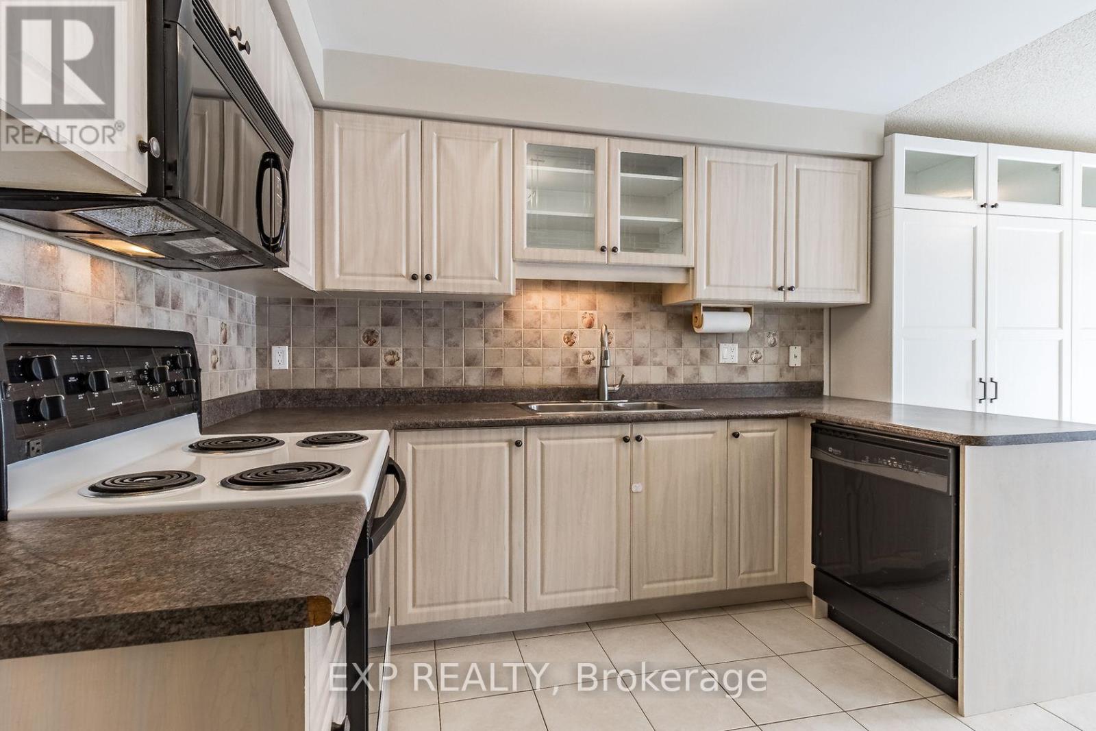 A kitchen with a stove top oven and a refrigerator.