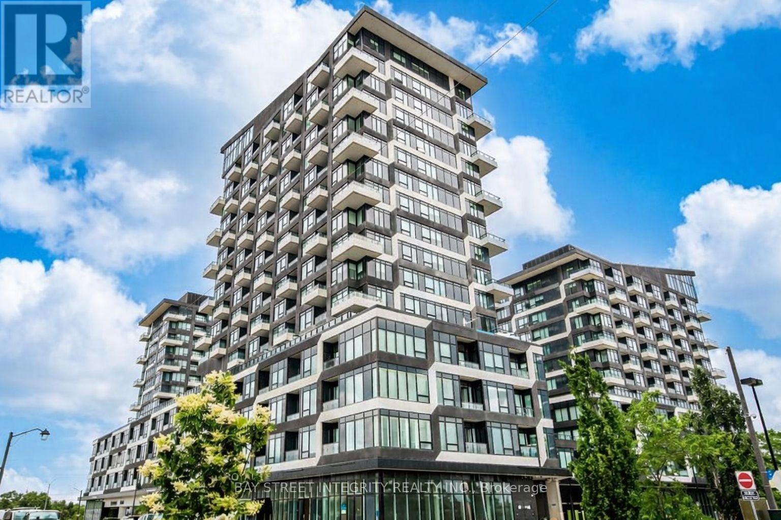 A tall residential building with balconies and a sign that reads "REALTOR".