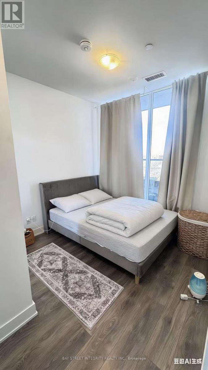 A bedroom with a bed, a basket, and a rug.
