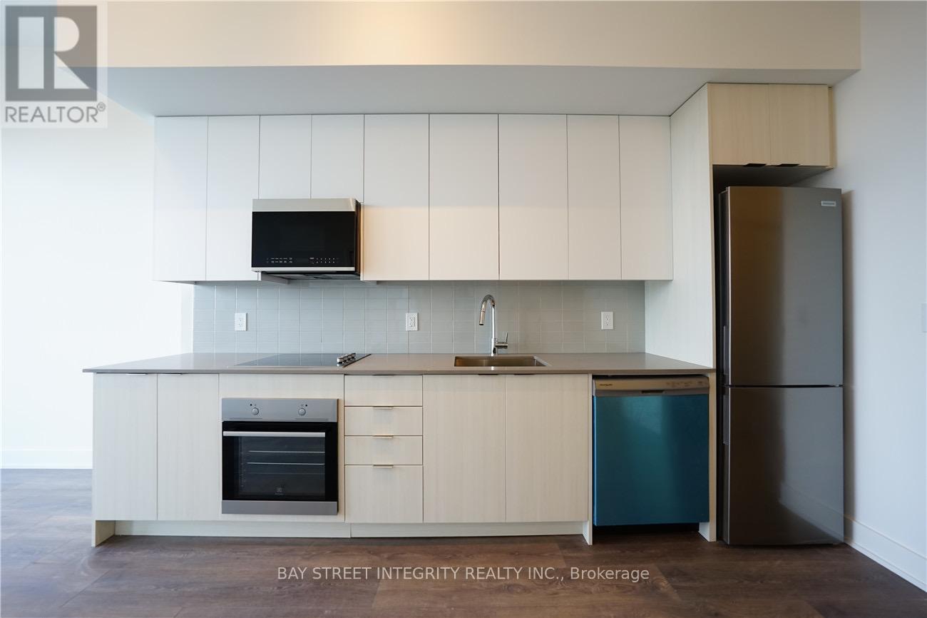 A kitchen with white cabinets and a black microwave above the stove.