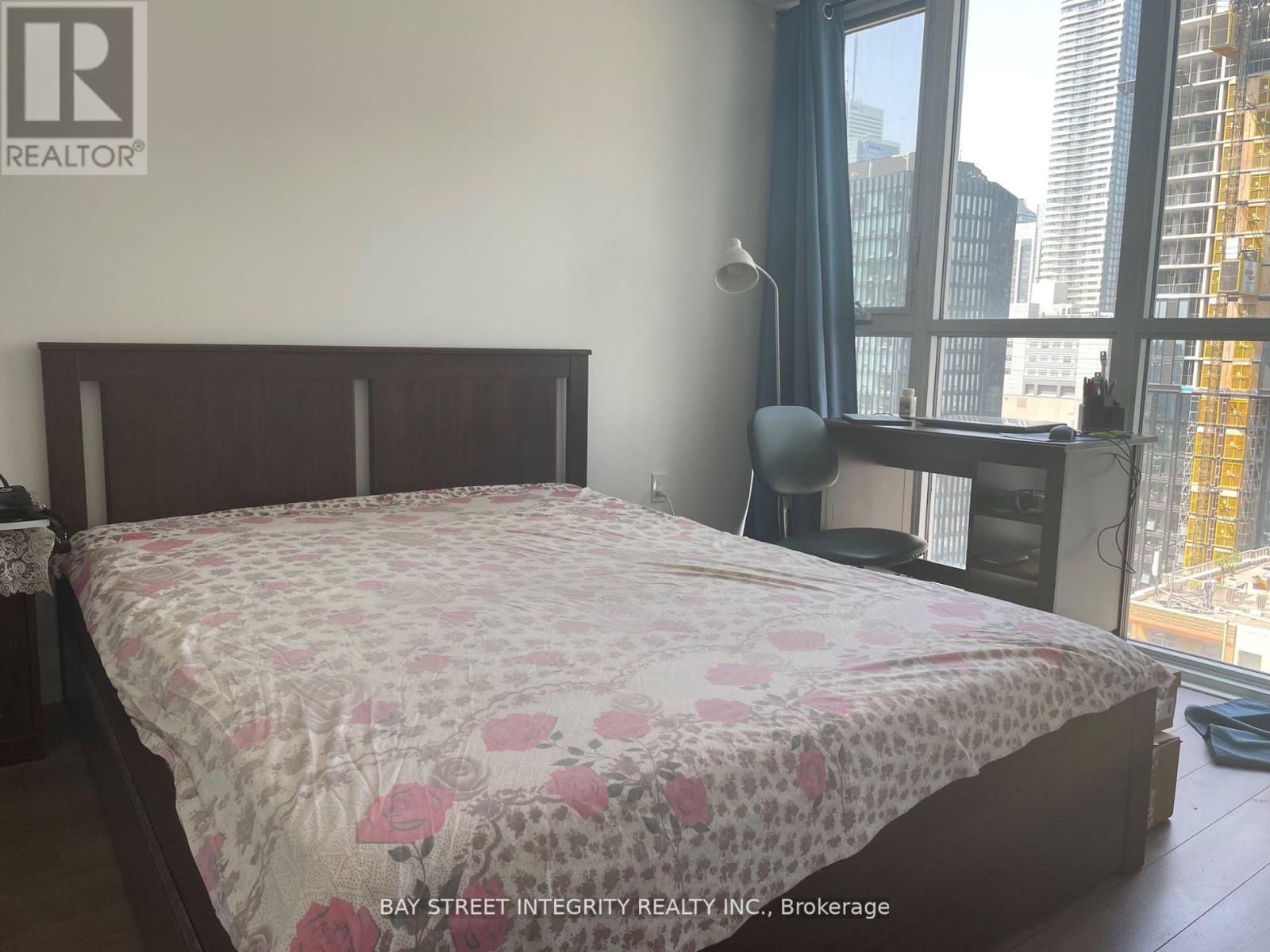 A bedroom with a large bed and a view of the city.