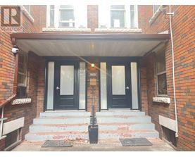 A brick building with a black door and a sign that says REALTOR.