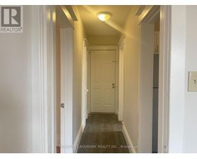 A hallway with a door at the end and a light on the ceiling.