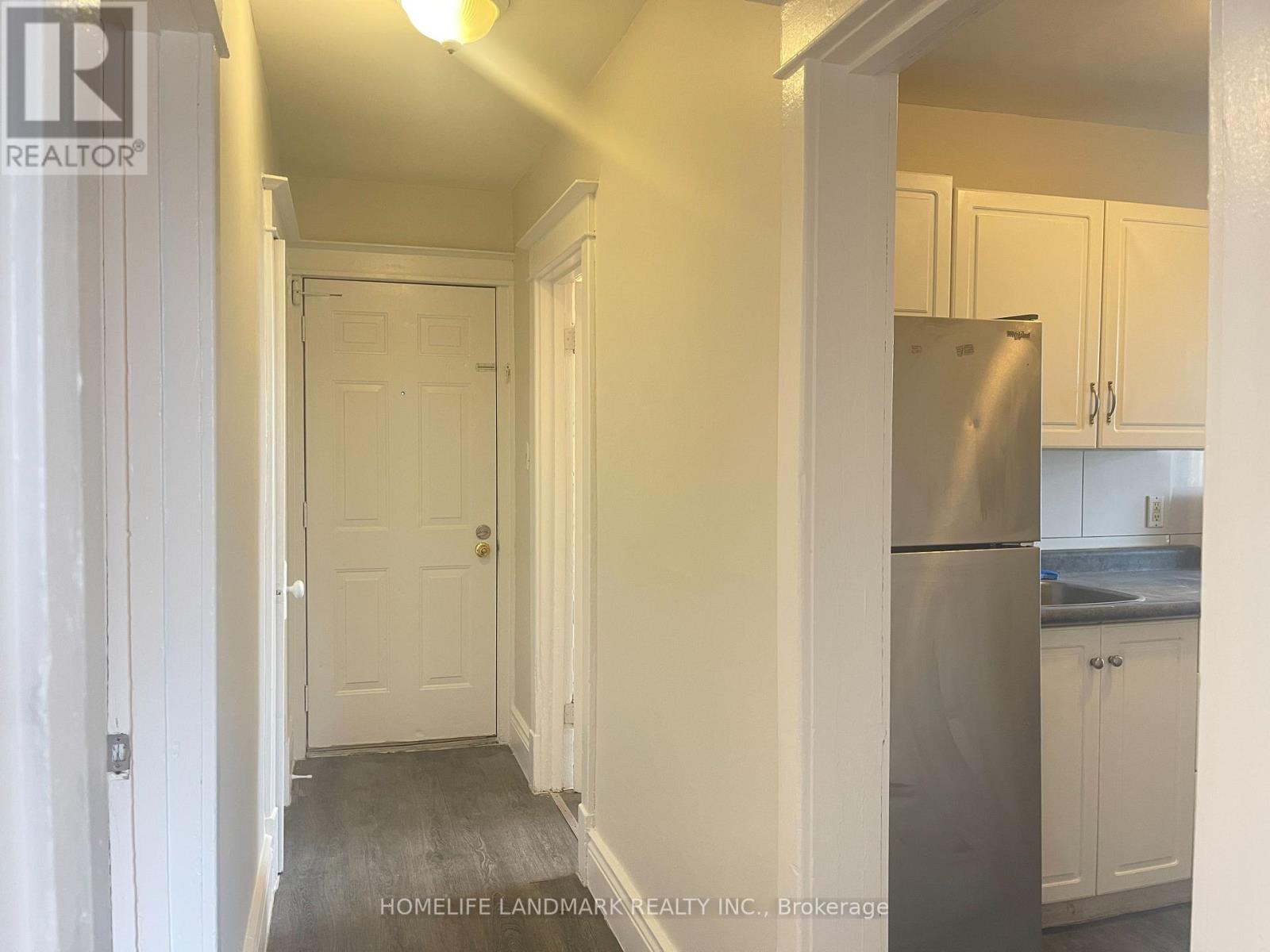 A kitchen with white cabinets and a stainless steel refrigerator.