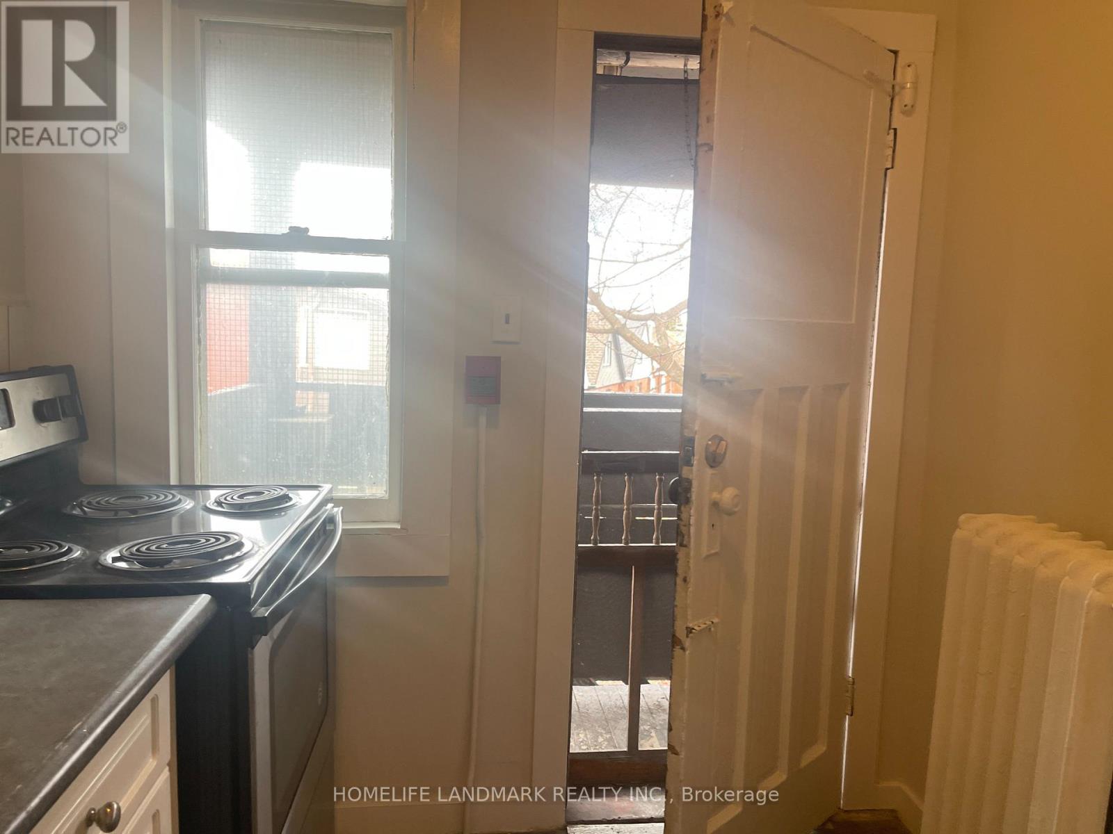 A small kitchen with a stove and a window.