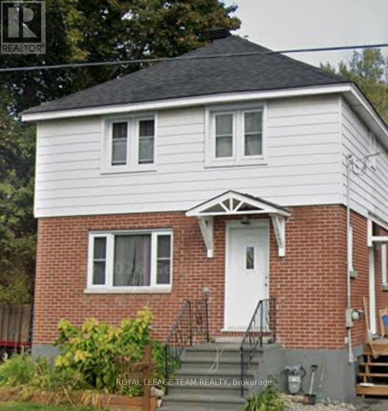 A white house with a red brick chimney is for sale.