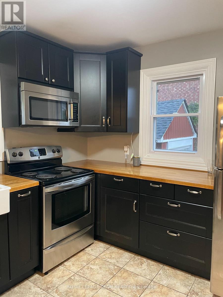 A kitchen with black cabinets and stainless steel appliances.