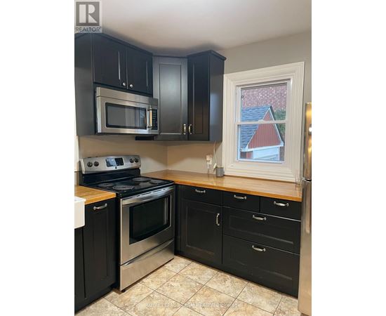 A kitchen with black cabinets and stainless steel appliances.