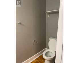 A white toilet in a small bathroom.