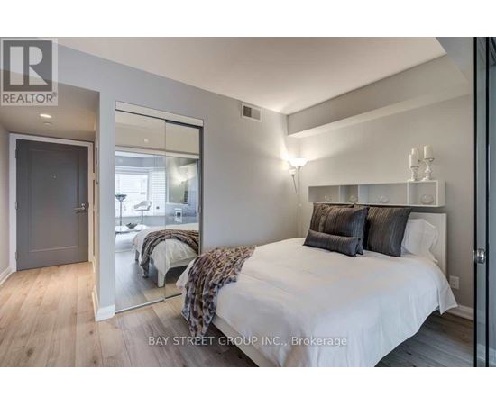 A bedroom with a large bed and a mirror on the wall.