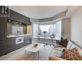 A modern kitchen with a breakfast table and a couch with pillows.