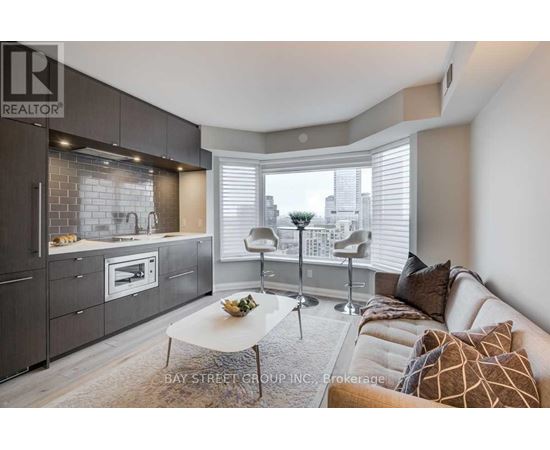 A modern kitchen with a breakfast table and a couch with pillows.