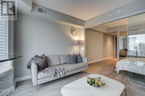 A modern living room with a glass table and a white sofa.