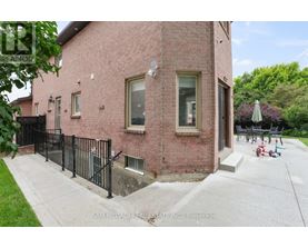 A red brick house with a black fence in front.