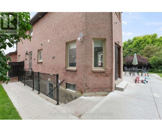 A red brick house with a black fence in front.