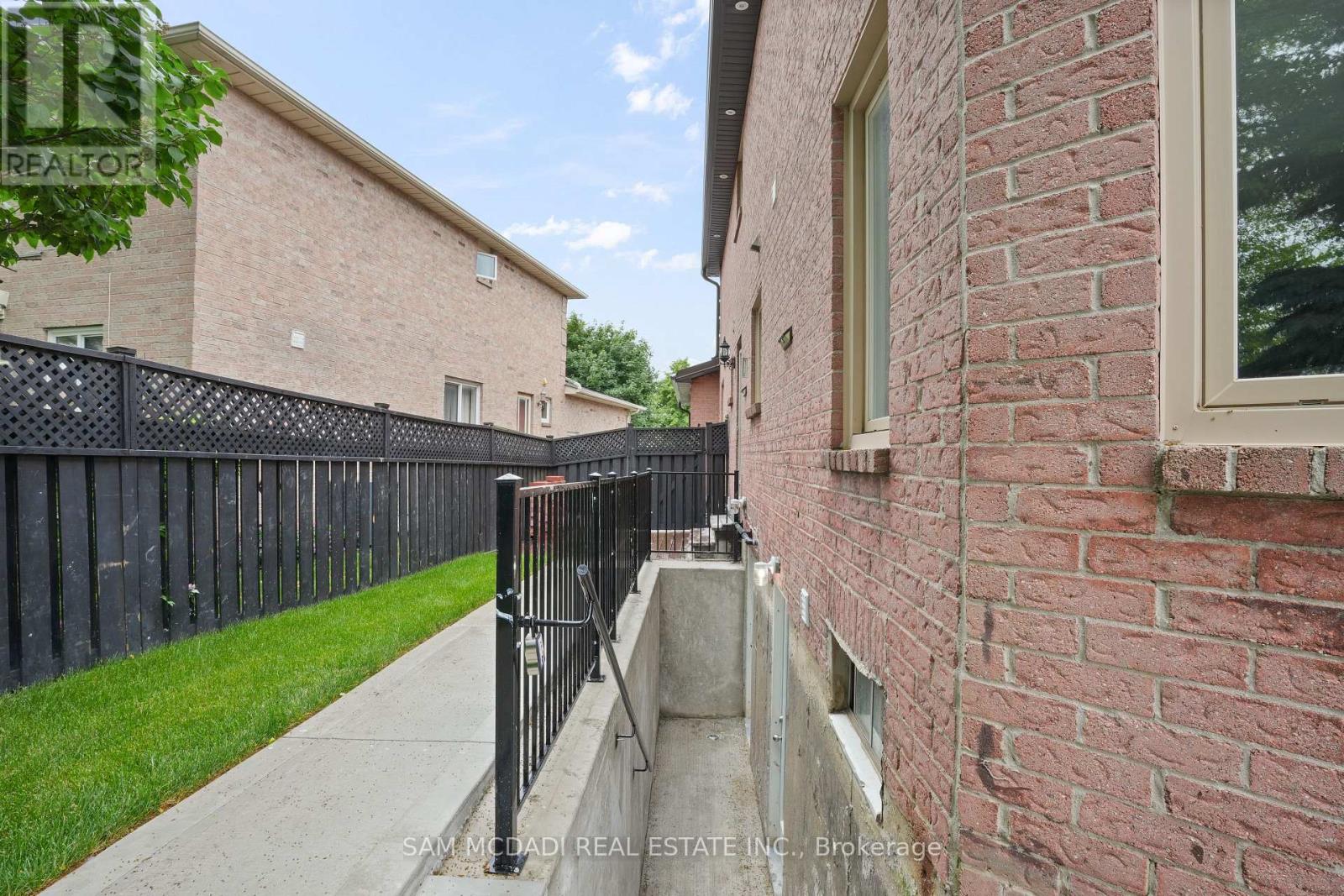 A brick building with a black fence in front.